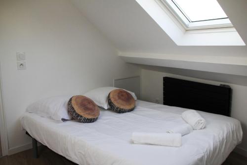 een slaapkamer met een bed met twee hoeden en handdoeken bij L'appart T2 de la gare - Cambrai in Cambrai