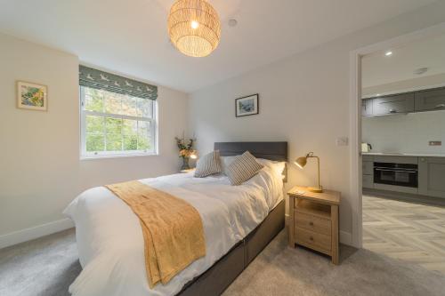 a bedroom with a large bed and a kitchen at Rock Mill - Deluxe 1-Bedroom Apartments in Stony Middleton