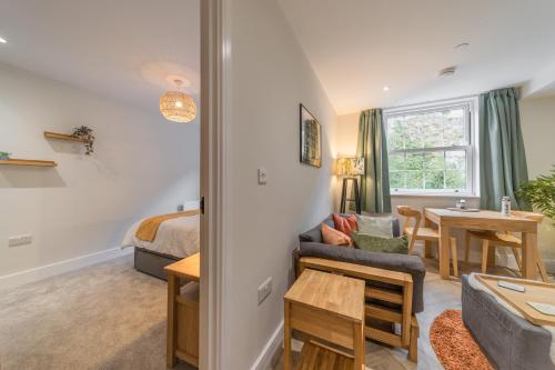 a living room with a bed and a table at Rock Mill - Deluxe 1-Bedroom Apartments in Stony Middleton