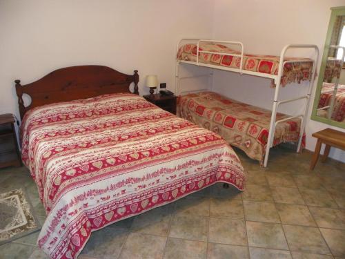 a bedroom with two bunk beds and a tiled floor at Hotel Les Granges in La Thuile