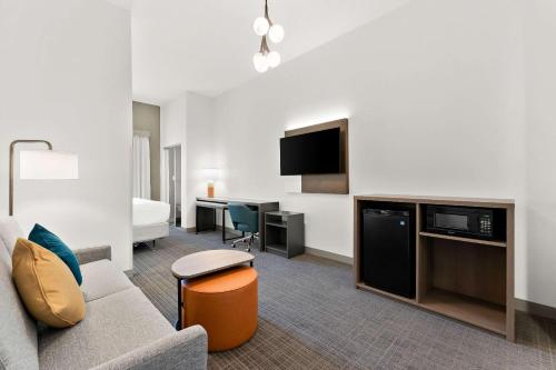 a hotel room with a couch and a tv at Comfort Inn & Suites Tunkhannock in Tunkhannock