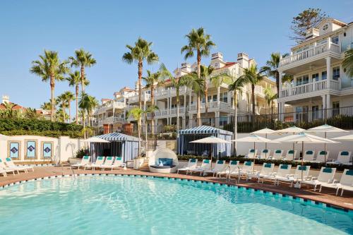 a swimming pool in front of a hotel with palm trees at Beach Village at The Del, LXR Hotels & Resorts in San Diego