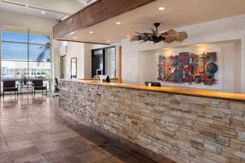 a bar in a home with a stone wall at Ramada by Wyndham Tucson in Tucson