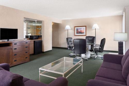 a hotel room with a living room with a couch and chairs at Ramada by Wyndham Tucson in Tucson