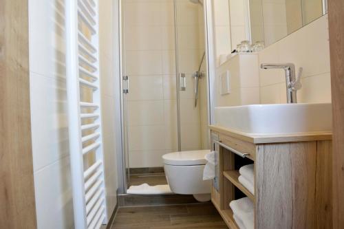 a bathroom with a sink and a toilet and a shower at Hotel Restaurant "Zur Post" in Holdorf