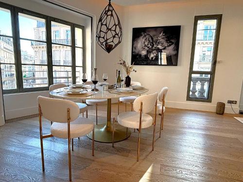 une salle à manger avec une table, des chaises et des verres dans l'établissement L'appartement Matignon, à Paris