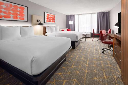 a hotel room with two beds and a desk at Hawthorn Extended Stay by Wyndham Columbia-Ft Jackson in Columbia