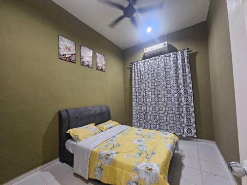 une chambre avec un lit et un ventilateur de plafond dans l'établissement Melaka Homestay Norelsya Bemban, à Bemban