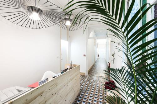 un pasillo con una palmera en un edificio en La Casa de Antonio Boutique Rooms en Barcelona