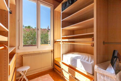 Cette petite chambre dispose d'étagères en bois et d'une fenêtre. dans l'établissement Villa Granier, à Marseille