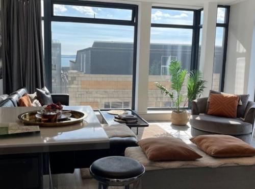 a living room with a couch and a large window at THE PAD by the beach Penthouse apartment with sunset and city views in Bournemouth