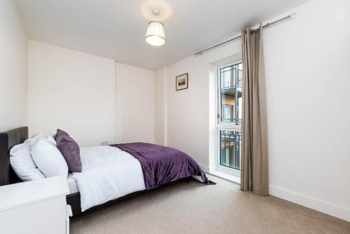 a white bedroom with a bed and a window at Greenwich House in London