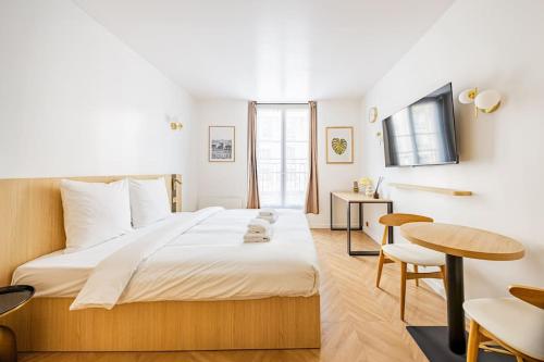 une chambre avec un grand lit et une table dans l'établissement 153 Suite luxueuse-Etienne Marcel-Châtelet-Paris 3, à Paris