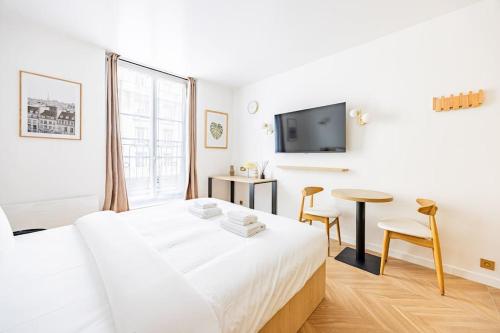 - une chambre blanche avec un lit blanc et une table dans l'établissement 153 Suite luxueuse-Etienne Marcel-Châtelet-Paris 3, à Paris