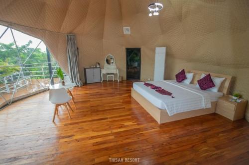 a bedroom with a large bed and a wooden floor at Thisak Resort Cheung phnom kulen in Siem Reap