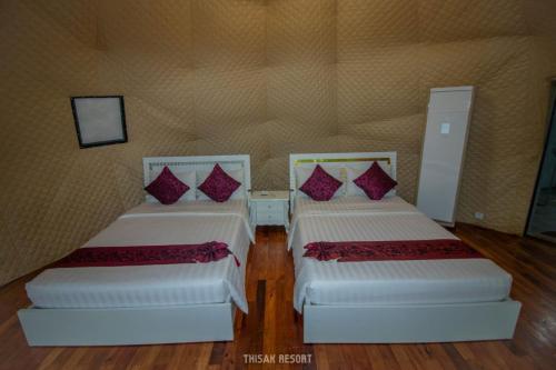 two beds in a room with wooden floors at Thisak Resort Cheung phnom kulen in Siem Reap