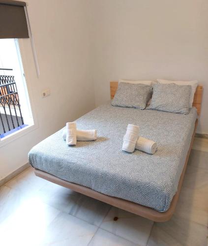 a bedroom with a bed with rolled towels on it at La Central Sevilla in Seville
