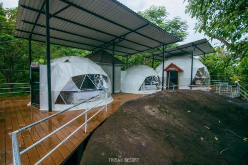 two white tents on a wooden deck with trees at Thisak Resort Cheung phnom kulen in Siem Reap
