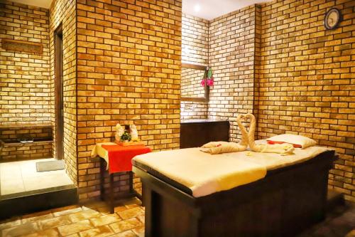 a room with a bed and a brick wall at Deventure Shimla Hills in Kandāghāt