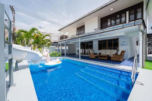 a pool in the backyard of a house with a water slide at Greta Villa Pattaya ใกล้ชายหาด ใจกลางเมือง in North Pattaya