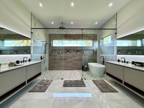 a bathroom with two sinks and a bath tub at Villa Twenty Two by CoralVilla - modern, pool & spa in Shell Point Village
