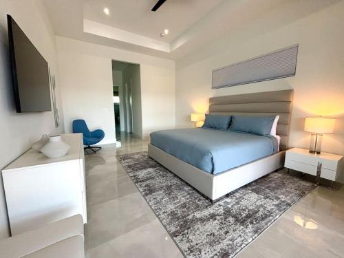 a bedroom with a bed and a tv in it at Villa Twenty Two by CoralVilla - modern, pool & spa in Shell Point Village