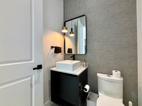 a bathroom with a sink and a toilet and a mirror at Villa Twenty Two by CoralVilla - modern, pool & spa in Shell Point Village
