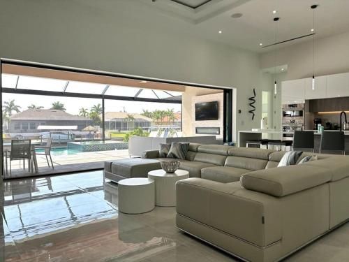 a living room with a large couch and a kitchen at Villa Twenty Two by CoralVilla - modern, pool & spa in Shell Point Village