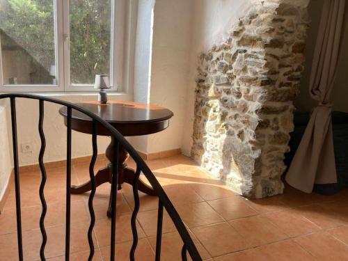a table in a room with a stone wall at Nid Douillet à Hyères in Hyères