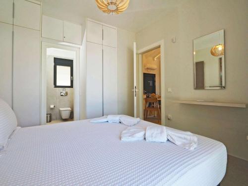 a bedroom with a white bed with towels on it at Gaia by Vintage Travel in Ágios Dimítrios