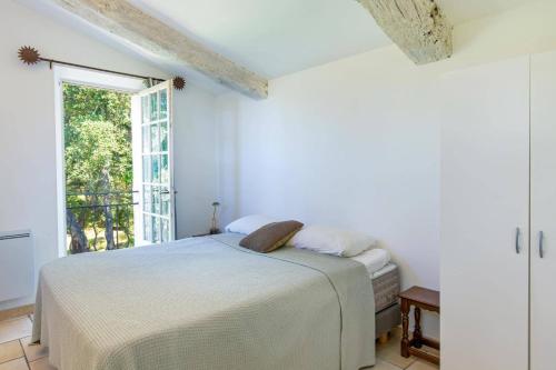 une chambre blanche avec un lit et une fenêtre dans l'établissement Villa Emeraude by Villa Plus, à Mandelieu-la-Napoule