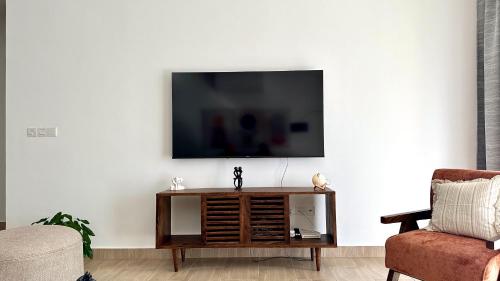 a living room with a tv on a white wall at The SandCastle Apartment in Ukunda