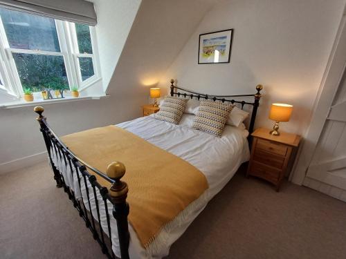 a bedroom with a bed and two lamps and two windows at Creel Cottage Seatown Cullen with Garden in Cullen