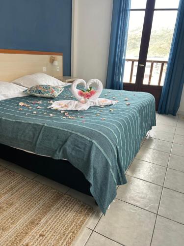 two swans are sitting on a bed in a bedroom at Hôtel de la jetée in Centuri