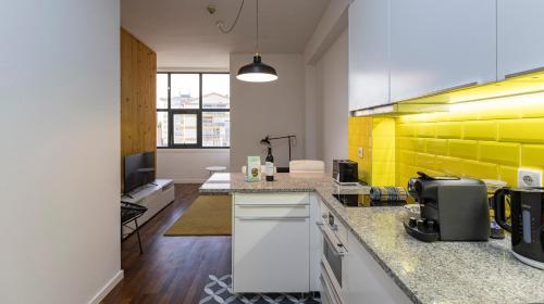 a kitchen with yellow accents on the wall at Boavista 1774 by LovelyStay in Porto