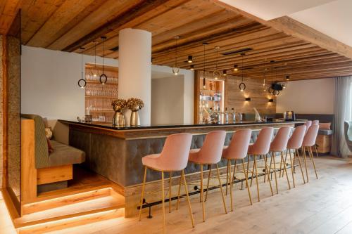 a bar with a row of stools at Natur- und Wohlfühlhotel Kastenholz in Wershofen