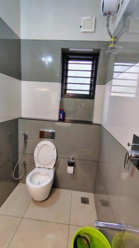 a bathroom with a toilet and a window at HRISHI Guest Suites 2BHK in Trivandrum
