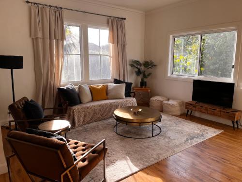 a living room with a couch and a table at Hidden Hedges - 5 min walk to town in Daylesford