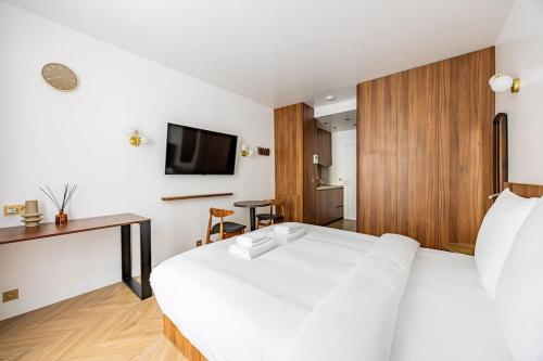 Cette chambre comprend un lit blanc et un bureau. dans l'établissement 152 Suite luxueuse-Etienne Marcel-Châtelet-Paris 3, à Paris
