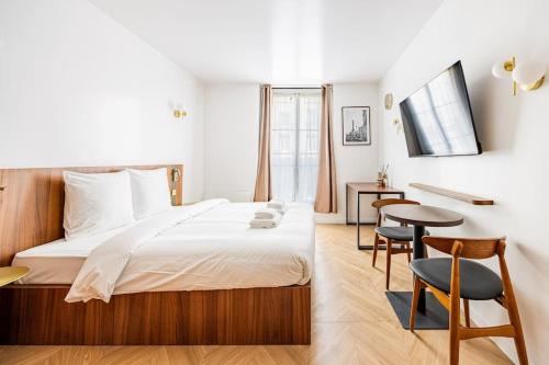 une chambre avec un lit, une table et des chaises dans l'établissement 152 Suite luxueuse-Etienne Marcel-Châtelet-Paris 3, à Paris