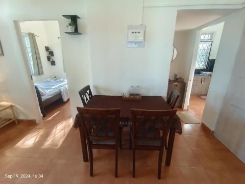 a dining room with a wooden table and chairs at Beachside Apartment - Cozy By The Sea Goa in Panaji