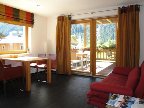 レンゲンフェルトにあるFerienwohnungen Vier Jahreszeitenのリビングルーム(テーブル、椅子付)、バルコニーが備わります。