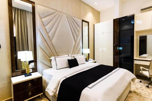 a bedroom with a large bed and a mirror at Yellow Trumpet Residence Asokoro in Asokoro