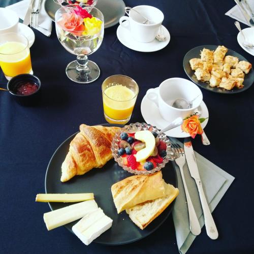 a table with a plate of breakfast foods and drinks at Plgfe - Maison d'hôtes EPICUROOMS - Suites romantiques 5 étoiles in Gallargues-Le-Montueux
