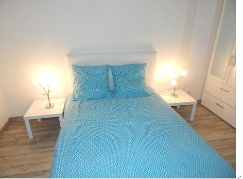 - un lit bleu avec des oreillers bleus dans une chambre dans l'établissement ST Malo Bel appartement prés gare plage du sillon parking privé, à Saint-Malo