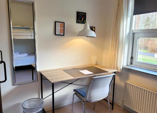 a desk in a room with a chair and a window at Aarhus Hostel og Hotel in Aarhus