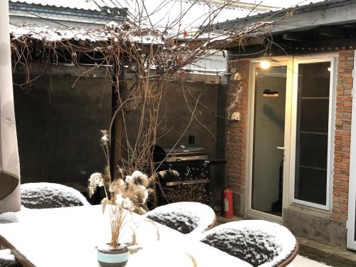 a snow covered patio with a table and chairs at 北京怀柔福喜山慕田峪长城特色民宿 in Beizhai