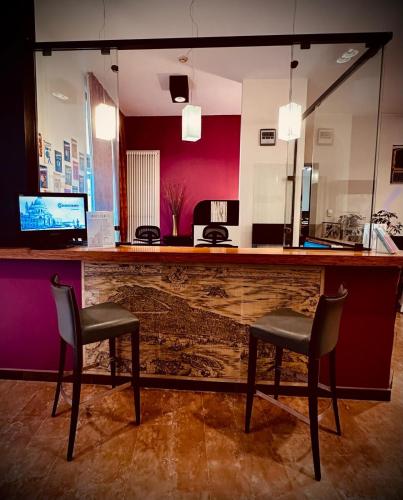 a bar with two chairs and a mirror at Domus Ciliota in Venice