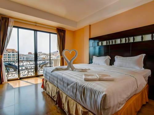 a bedroom with a large bed with a heart statue on it at Land Royal Residence Pattaya in Pattaya South