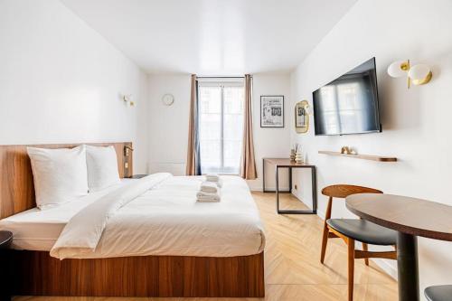 - une chambre avec un grand lit, une table et un bureau dans l'établissement 151 Suite luxueuse-Etienne Marcel-Châtelet-Paris 3, à Paris